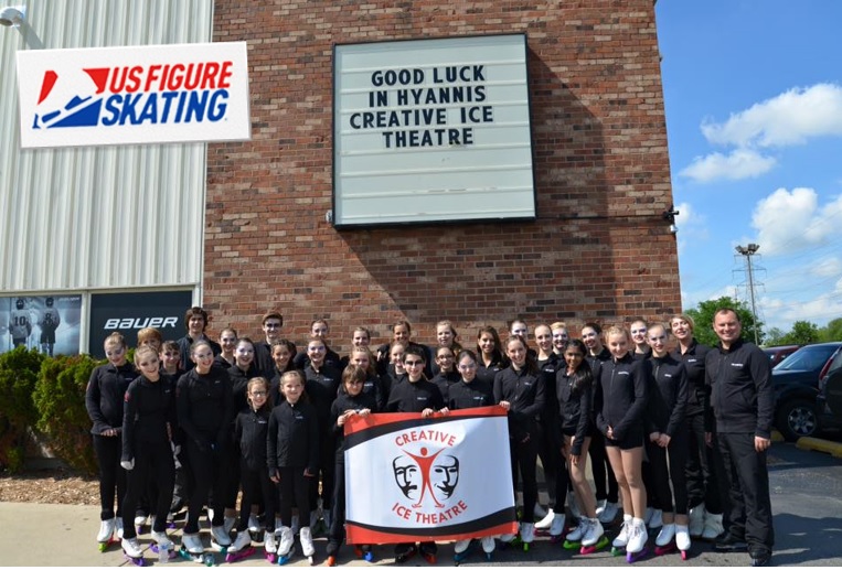 The Creative Ice Theatre Company infront of a rink that says Good Luck CIT.